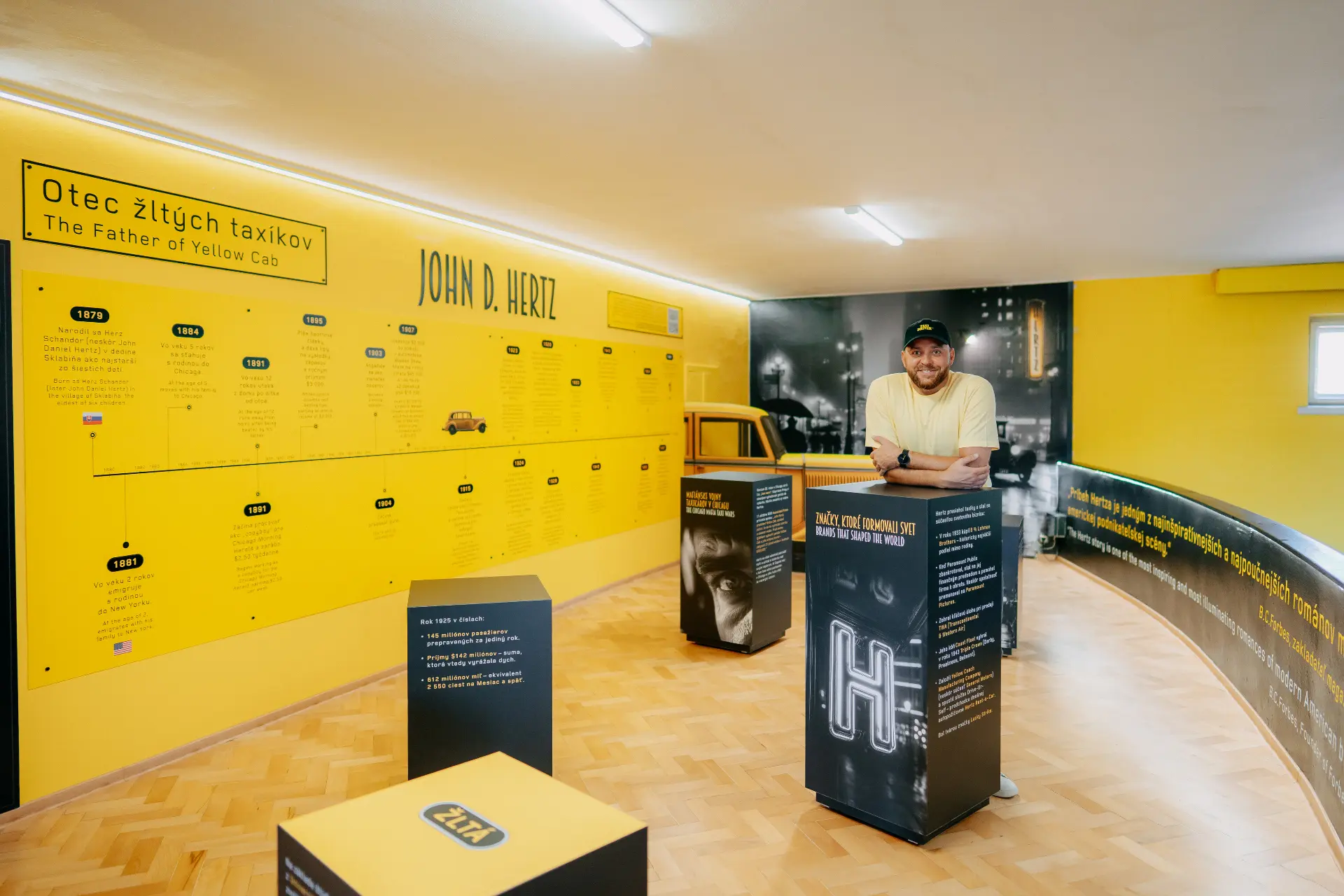 The Hertz Inspirational Room exhibition in Sklabiňa — yellow timeline wall and exhibits